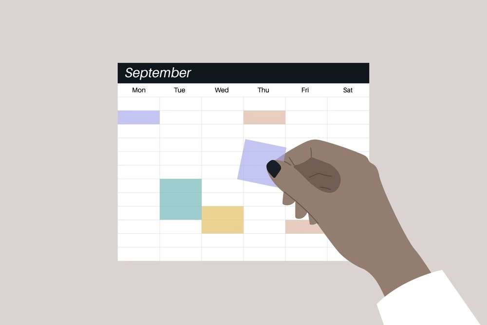 hand putting notes on paper calendar